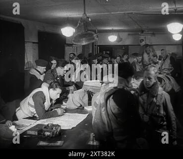 RAF Pilots Planning and Chatting with other, 1942. La Gran Bretagna durante la seconda guerra mondiale. "...un momento di crisi... una partita difficile in cui sembrava che gli dei avessero decretato che dovevamo sempre uscire dal peggio... eppure giorno dopo giorno continuavamo a lavorare, pianificare, combattere...". Da Time to Remember - The End of the Beginning, 1942 (Reel 1); film documentario sugli eventi del 1942 e l'entrata in guerra dell'America. Foto Stock