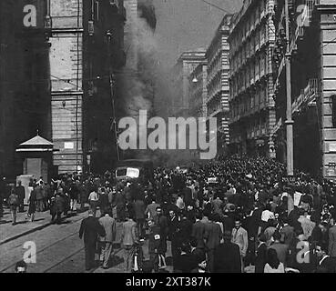 Civili italiani che si muovono lentamente attraverso Napoli, danneggiata da bombe, 1943-1944. Da "Time to Remember - The Path to Rome", 1943 - 1944 (Reel 1); documentario sugli eventi del 1943 e del 1944 - la campagna italiana. Foto Stock