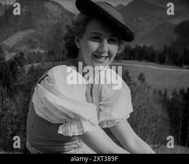 Eva Braun seduta su un muro, 1942. Seconda guerra mondiale: Berchtesgaden nelle Alpi tedesche. La signora conosciuta alla corte nazista come Eva Braun, l'amica del Fuhrer. Da Time to Remember - The End of the Beginning, 1942 (Reel 4); film documentario sugli eventi del 1942 e l'entrata in guerra dell'America. Foto Stock