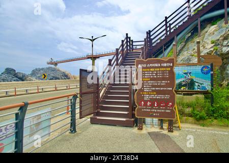Contea di Uljin, Corea del Sud - 27 luglio 2024: L'ingresso al Deunggi Mountain Skywalk, segnato da un cartello informativo, guida i visitatori all'eleva Foto Stock