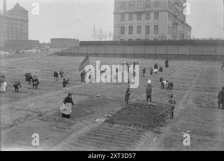 Giardino Rockefeller, 1917. Mostra i bambini giardinaggio in un Rockefeller Garden nella sua nuova posizione in 65th Street e Avenue A nel maggio 1917. La National Plant, Flower and Fruit Guild curava il giardino donato dalla Rockefeller Foundation. Grande edificio con il cartello "Central Brewing Co." sullo sfondo. Foto Stock