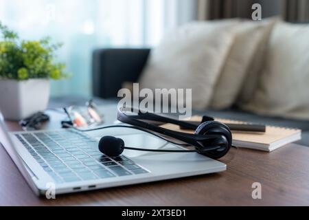 Auricolare, servizio di assistenza telefonica in ufficio. Auricolare VOIP sulla scrivania con computer portatile. Foto Stock