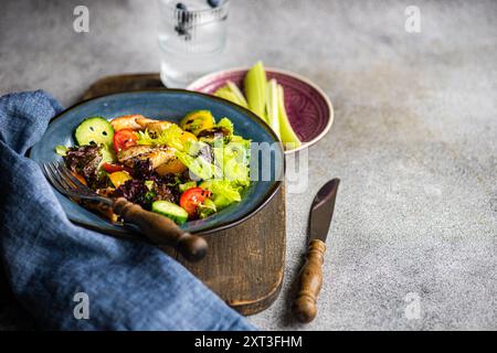 Dall'alto una sana insalata fatta in casa con pollo alla griglia, lattuga, pomodori ciliegini, cetrioli, peperoni, e semi di sesamo, serviti splendidamente Foto Stock