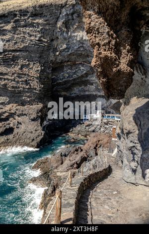 Ripide scogliere rocciose che torreggiano sul pittoresco villaggio di Poris de Candelaria, con sentieri rustici che scendono verso l'Oceano Atlantico a la Palma, Canar Foto Stock