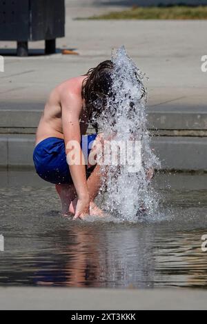 Fiume Mincio, Peschiera del Garda. 13 agosto 2024. Le condizioni delle ondate di calore persistettero in gran parte dell'Europa oggi, compreso il Lago di Garda e i dintorni dell'Italia settentrionale. Le temperature diurne dovrebbero raggiungere oggi i 37 gradi Celsius all'ombra. Gente che cerca di stare al fresco a Peschiera del Garda, sul lato sud del Lago di Garda, nel nord Italia. Crediti: james jagger/Alamy Live News Foto Stock