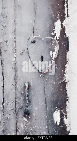 Antica porta con serratura a forma di cuore e maniglia. Foto Stock