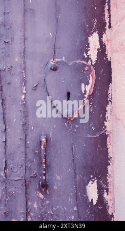 Antica porta con serratura a forma di cuore e maniglia. Foto tonificata. Foto Stock