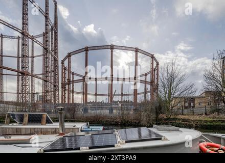 Bethnal Green Gasworks, Marian Place, Bethnal Green, Tower Hamlets, Greater London Authority, 2021. vista generale guardando a sud-est attraverso il Regent Canal verso Bethnal Green Gasworks, con pannelli solari sul tetto di una barca ormeggiata sul canale in primo piano. Foto Stock