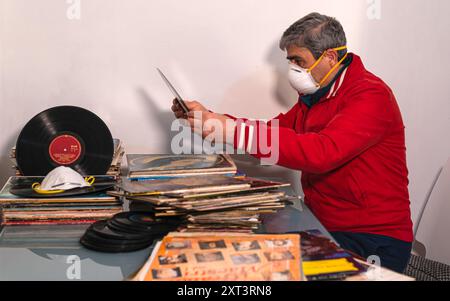 Modugno, Italia - 12 marzo 2020: A casa per la quarantena pandemica del coronavirus COVID-19. Appassionato audiofilo ordina la sua collezione di vinile Foto Stock