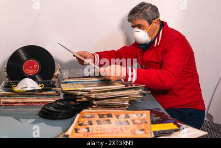 Modugno, Italia - 12 marzo 2020: A casa per la quarantena pandemica del coronavirus COVID-19. Appassionato audiofilo ordina la sua collezione di vinile Foto Stock