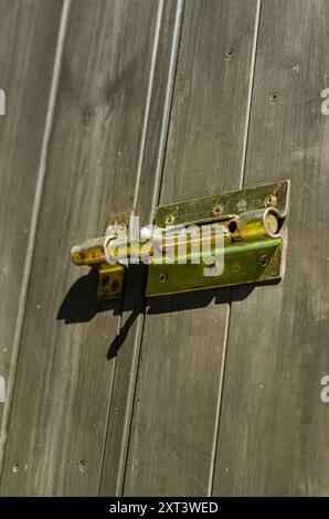 porta in legno con serratura a bullone in metallo, che mostra texture e dettagli in sicurezza. Foto di alta qualità Foto Stock