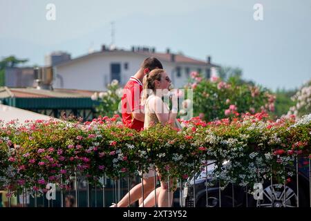 Fiume Mincio, Peschiera del Garda. 13 agosto 2024. Le condizioni delle ondate di calore persistettero in gran parte dell'Europa oggi, compreso il Lago di Garda e i dintorni dell'Italia settentrionale. Le temperature diurne dovrebbero raggiungere oggi i 37 gradi Celsius all'ombra. Gente che cerca di stare al fresco a Peschiera del Garda, sul lato sud del Lago di Garda, nel nord Italia. Crediti: james jagger/Alamy Live News Foto Stock