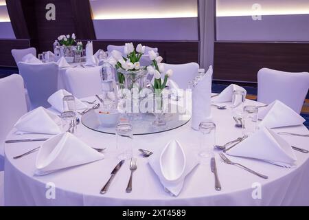 Sedie e tavoli decorati con piatti bianchi e fiori e canne naturali viola e bianchi, decorazioni e decorazioni per matrimoni, concetto floristico Foto Stock