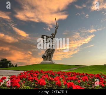 Russia, Volgograd - 01 giugno 2024: Vista della scultura Patria chiama Mamayev Kurgan. In primo piano c'è un'aiuola con il pelargonium scarlatto Foto Stock