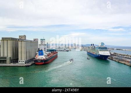 Barcellona, Spagna - 25 maggio 2024: Vista del porto con la portarinfuse Golden Fast presso i silos di grano e la nave da crociera Celebrity Equinox presso il terminal passeggeri Foto Stock