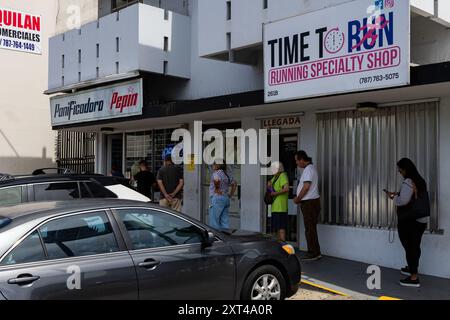 San Juan, Stati Uniti. 13 agosto 2024. I portoricani attendono in fila presso una panetteria per fare scorta di pane e altri cibi prima della tempesta tropicale Ernesto a San Juan, Porto Rico, il 13 agosto 2024. Tropical Storm Ernesto è pronto a colpire l'arcipelago tra martedì sera e mercoledì mattina. Crediti: SIPA USA/Alamy Live News Foto Stock