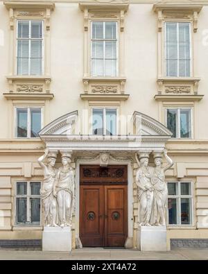 Statue in marmo scolpito supportano l'ingresso all'edificio degli uffici a Vienna in Austria Foto Stock