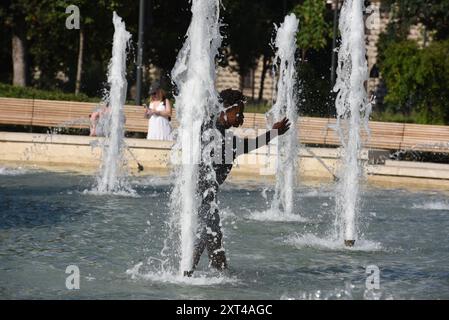 Milano, Italia. 13 agosto 2024. I turisti cercano un rinfresco nella fontana di fronte al Castello Sforzesco. L'ondata di caldo che ha colpito l'Italia continua, con temperature fino a 41 gradi registrate a Firenze, in Toscana, due giorni fa. La situazione dovrebbe migliorare, anche con un calo delle temperature minime, a partire dal fine settimana (Credit Image: © Ervin Shulku/ZUMA Press Wire) SOLO USO EDITORIALE! Non per USO commerciale! Foto Stock