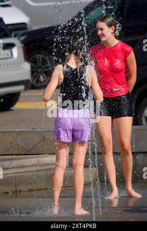 Fiume Mincio, Peschiera del Garda. 13 agosto 2024. Le condizioni delle ondate di calore persistettero in gran parte dell'Europa oggi, compreso il Lago di Garda e i dintorni dell'Italia settentrionale. Le temperature diurne dovrebbero raggiungere oggi i 37 gradi Celsius all'ombra. Gente che cerca di stare al fresco a Peschiera del Garda, sul lato sud del Lago di Garda, nel nord Italia. Crediti: james jagger/Alamy Live News Foto Stock