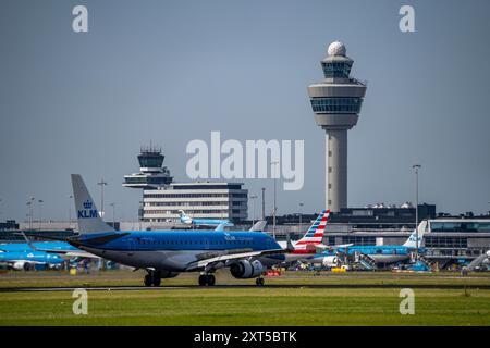 KLM Embraer E190STD atterrando presso l'aeroporto Schiphol di Amsterdam, Buitenveldertbaan, 09/27, Air Traffic Control Tower, Terminal, Paesi Bassi, Foto Stock