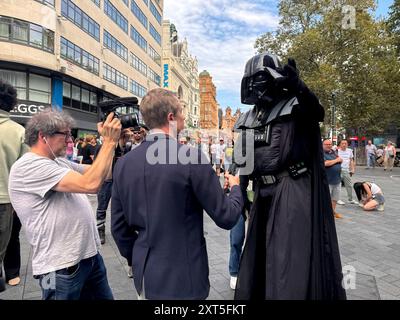 LEADER SQUARE STABBING © Jeff Moore - Un artista di strada, vestito da Darth Vader, viene intervistato dai media dopo aver affermato di aver visto Foto Stock