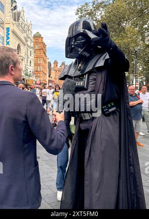 LEADER SQUARE STABBING © Jeff Moore - Un artista di strada, vestito da Darth Vader, viene intervistato dai media dopo aver affermato di aver visto Foto Stock