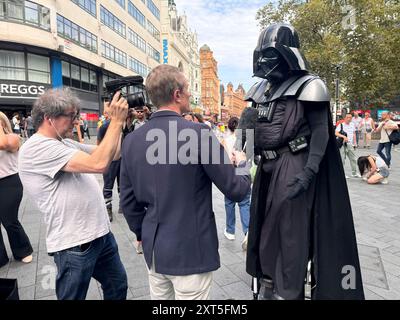 LEADER SQUARE STABBING © Jeff Moore - Un artista di strada, vestito da Darth Vader, viene intervistato dai media dopo aver affermato di aver visto Foto Stock