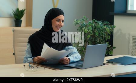 Donna islamica musulmana in hijab donna d'affari araba capo donna datore di lavoro sorridente consulente aziendale parlare videochiamata online conferenza portatile Foto Stock