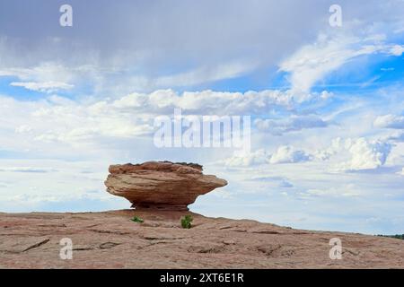 La formazione di arenaria resistente agli agenti atmosferici si trova sotto un cielo dinamico pieno di nuvole Foto Stock