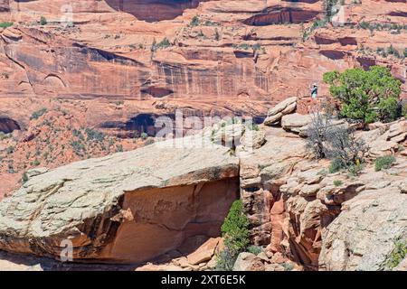 Turista che si gode la maestosa vista delle pareti di arenaria nel Canyon de Chelly National Monument -- Chinle Arizona, aprile 2024 Foto Stock