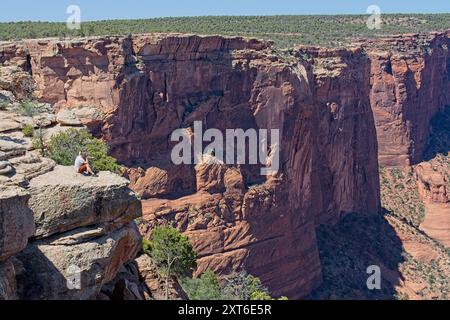 Turisti che si godono la maestosa vista delle pareti di arenaria nel Canyon de Chelly National Monument - Chinle Arizona, aprile 2024 Foto Stock