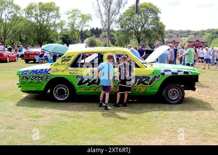 Due giovani curiosi sbirciano all'interno di una serie Rolls Royce/Bentley SZ smantellata, dipinta e segnalata pronta per il suo finale: Una corsa da brivido. Foto Stock