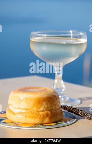 Dolce dolce italiano ricotta fresca al limone e bicchieri di spumante Prosecco servito sulla costa ligure con vista sul mare, estate Foto Stock