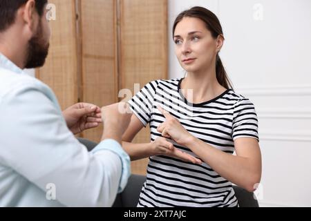 Uomo e donna che usano il linguaggio dei segni per comunicare a casa Foto Stock