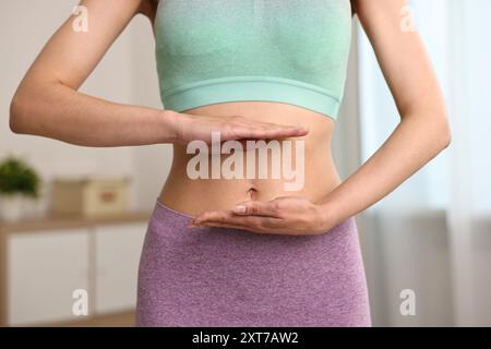 Digestione sana. Donna che tiene qualcosa vicino alla pancia dentro, primo piano Foto Stock