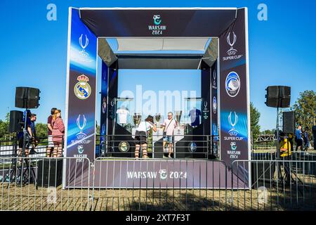 I visitatori fanno la fila per farsi fotografare accanto alla Coppa UEFA, al trofeo della Champions League e alla Supercoppa UEFA. I tifosi dei vincitori della Champions League spagnola, del Real Madrid e della Coppa UEFA italiana, l'Atalanta, si sono riuniti in piazza Kahla a Varsavia, accanto al fiume Vistola, per il festival dei tifosi della Supercoppa UEFA. In previsione della partita del giorno successivo, i visitatori fanno la fila per scattare foto con il trofeo e prendono parte a una serie di giochi e attività calcistiche. La Supercoppa UEFA si svolge al PGE Narodowy di Varsavia il 14 agosto 2024 ed è contesa dai vincitori del Champio Foto Stock