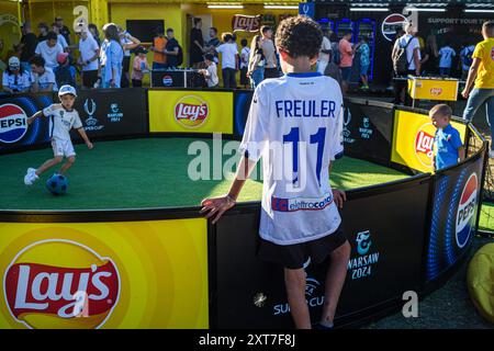 I giovani tifosi di calcio giocano a calcio 1vs1 al sole. I tifosi dei vincitori della Champions League spagnola, del Real Madrid e della Coppa UEFA italiana, l'Atalanta, si sono riuniti in piazza Kahla a Varsavia, accanto al fiume Vistola, per il festival dei tifosi della Supercoppa UEFA. In previsione della partita del giorno successivo, i visitatori fanno la fila per scattare foto con il trofeo e prendono parte a una serie di giochi e attività calcistiche. La Supercoppa UEFA si svolge al PGE Narodowy di Varsavia il 14 agosto 2024 ed è contesa dai vincitori della Champions League e della Coppa UEFA. (Foto di Neil Milton/SOPA Foto Stock