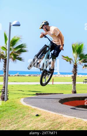 Un ragazzo che esegue una acrobazia con una bicicletta in uno skate Park a Tel Aviv, Israele Foto Stock