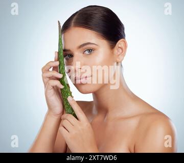 Ritratto, cura della pelle e donna con foglie di aloe vera per benefici isolati su sfondo bianco studio. Viso, cosmetici e modello con pianta naturale per Foto Stock