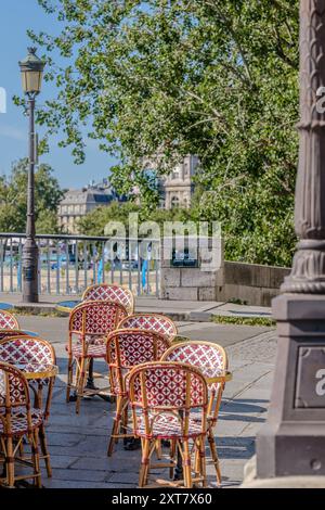 Parigi, Francia - 10 agosto 2024 : Vista delle sedie e dei tavoli tipici di un café-ristorante parigino vicino alla Senna a Parigi in Francia Foto Stock