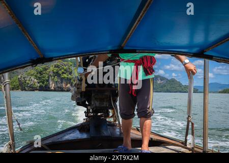 Phuket Thailandia ritratto dell'uomo che guida la barca in un giorno d'estate. I pescatori guidano una tradizionale barca tailandese a coda lunga in Thailandia. Foto di viaggio Foto Stock