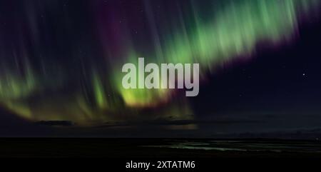 Il cielo è pieno di una bella mostra di aurore. I colori sono vivaci e il cielo è scuro Foto Stock