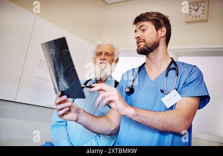 Ospedale, consultazione e infermiere con raggi x dall'uomo per lesioni corporee, valutazione o diagnosi medica. Persona anziana, paziente e professionista con Foto Stock