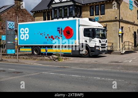 Camion blu per la consegna cooperativa parcheggiato fuori dal negozio del villaggio cooperativo, una casa pubblica convertita, con il cartello COOP e i cartelli del negozio in vista, ma non c'è nessuno Foto Stock
