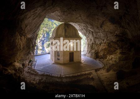 Il Tempio del Valadier, un tempio neoclassico scolpito nella parete rocciosa della Gola di Frasassi nelle Marche, in Italia, si erge come testimonianza dell'armonio Foto Stock