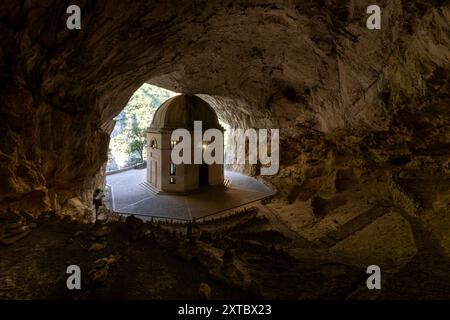 Il Tempio del Valadier, un tempio neoclassico scolpito nella parete rocciosa della Gola di Frasassi nelle Marche, in Italia, si erge come testimonianza dell'armonio Foto Stock