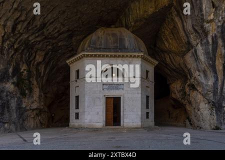 Il Tempio del Valadier, un tempio neoclassico scolpito nella parete rocciosa della Gola di Frasassi nelle Marche, in Italia, si erge come testimonianza dell'armonio Foto Stock