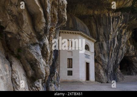 Il Tempio del Valadier, un tempio neoclassico scolpito nella parete rocciosa della Gola di Frasassi nelle Marche, in Italia, si erge come testimonianza dell'armonio Foto Stock