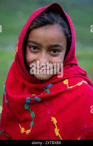 Peer Ki Gali, India, 14/08/2024, Una ragazza nomade kashmiri posa per una foto vicino al passo PIR Panjal, chiamato anche Peer Ki Gali, a circa 100 km a sud di Srinagar, la capitale estiva di Jammu e Kashmir. Il passo PIR Panjal è un passo di montagna e una destinazione turistica situata nella catena PIR Panjal di Jammu e Kashmir, che collega la valle del Kashmir ai distretti di Rajouri e Punch tramite Mughal Road. È il punto più alto della strada Mughal a 3.490 metri sul livello del mare. Mughal Road, come suggerisce il nome, è stata storicamente creata e utilizzata dagli imperatori moghul. Era la strada che ha preso Akbar Foto Stock