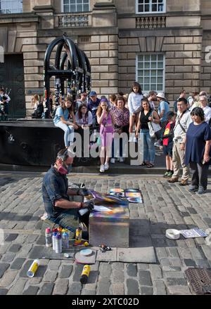 Disegnatore di vernice spray in Royal Mile Street. Edimburgo, Scozia, Regno Unito Foto Stock